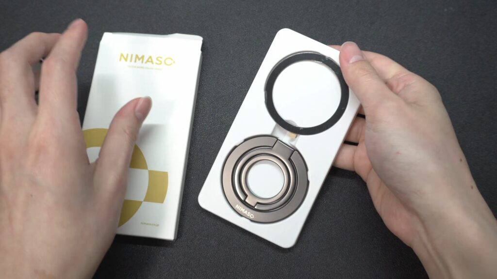 NIMASO MagSafeスマホリングのパッケージを開封した様子。下にリング本体、上に貼り付け用の金属MagSafeシールが入っている